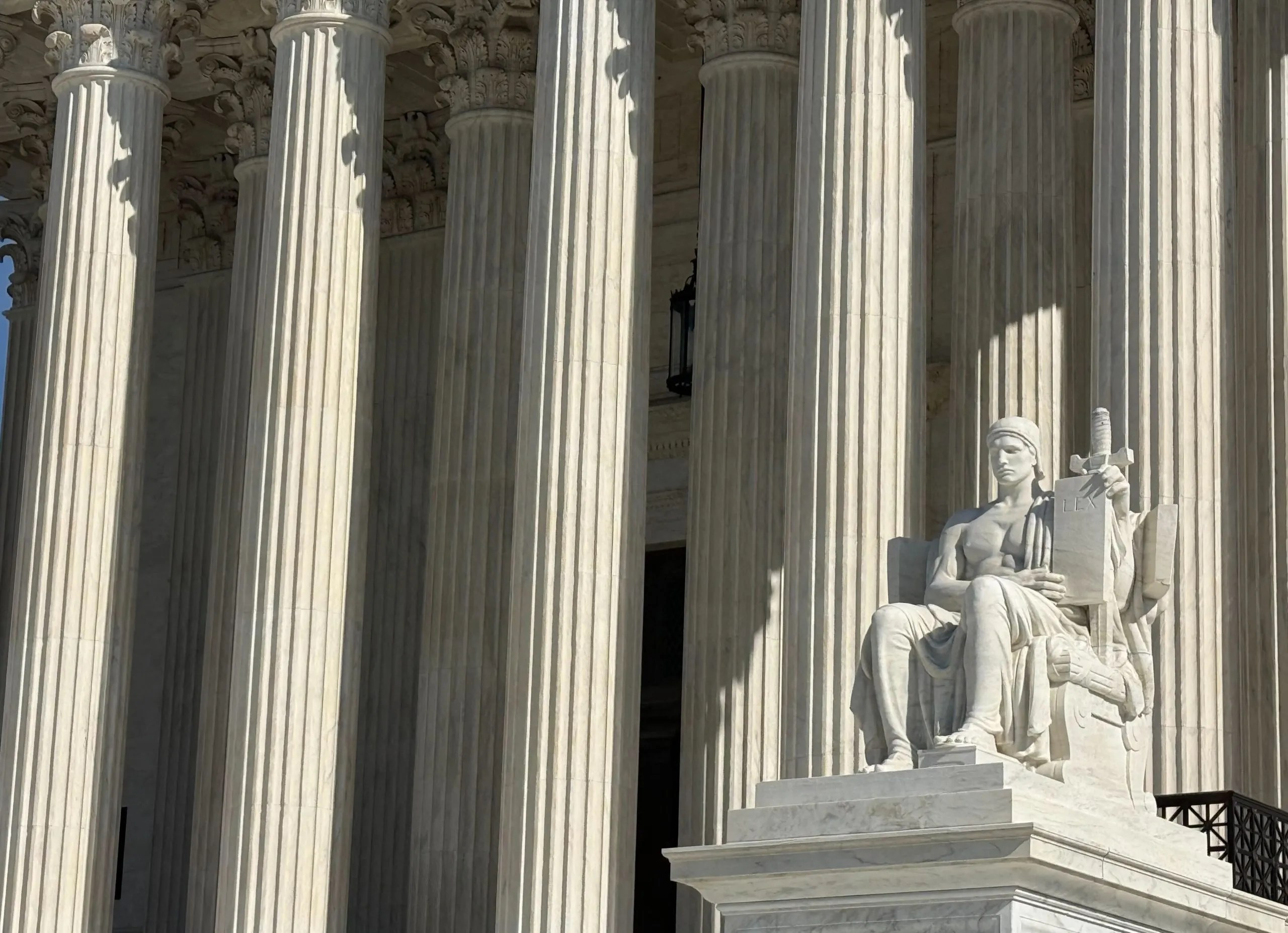 A statue is shown in front of the Supreme Court in Washington, D.C.
